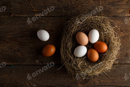Preview: Chicken eggs in a nest on a wooden rustic background