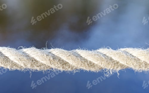 Preview: Close up detail of new white boat rope on water blue background