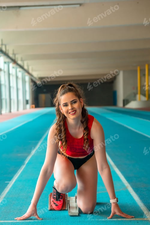 Preview: Vertical shot of a sprinter woman preparing for the start of the race in training