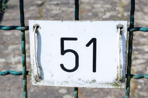 Preview: Closeup shot of a number plate on the fence with the number 51