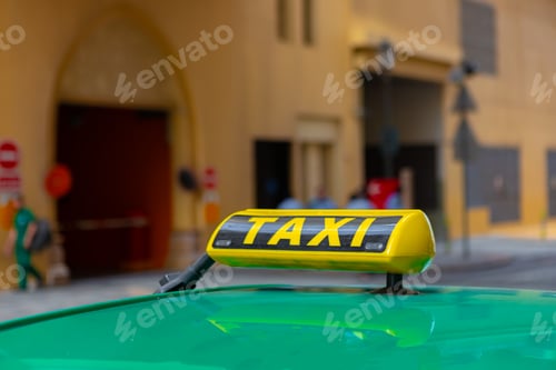 Preview: Taxi sign on the roof of a car in a street