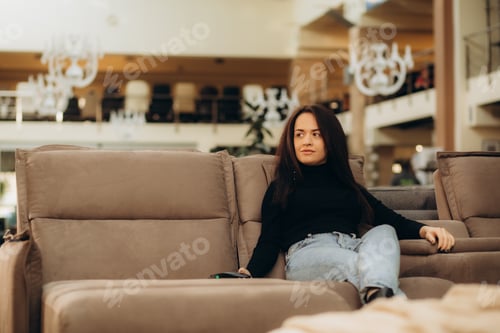 Preview: a woman sits on a sofa in a furniture store