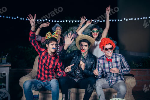 Preview: Happy friends having fun with costumes in a party