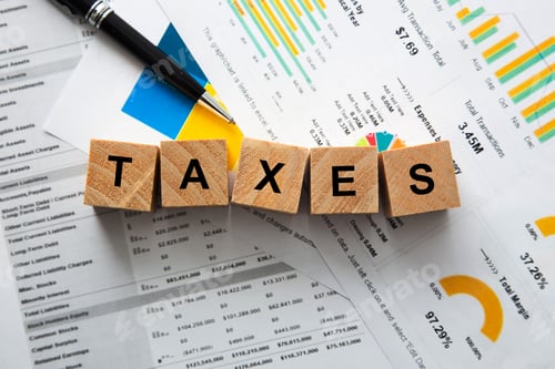 Preview: Taxes word on wooden blocks with financial documents