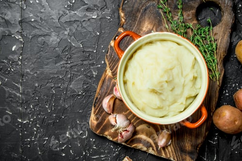 Preview: Mashed potatoes in a bowl with garlic and thyme.