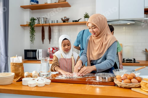 Preview: Young Asian muslim mother help and teach her daughter to threshing flour by hands on wooden tray