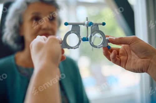 Preview: Close up of ophthalmologist using optical trial frame during patient's eyesight exam.