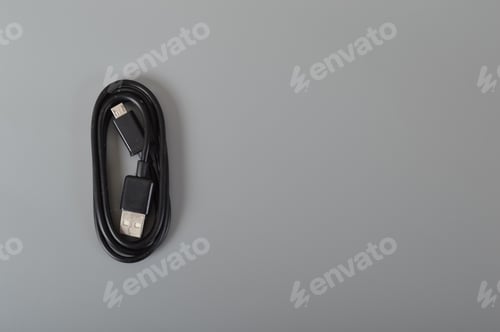 Preview: Mobile phone cable isolated on a grey background.