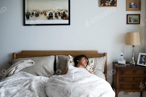 Preview: Senior woman sleeping alone on the bed