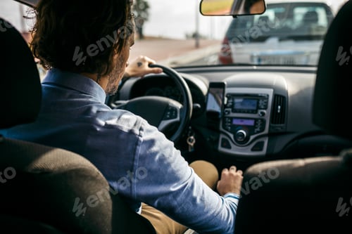 Preview: Rear view of businessman driving car