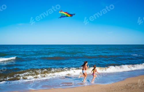 Preview: Two little happy cheerful girls run with a kite