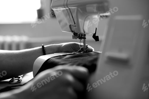 Preview: Black and white photo of Man sews clothes on sewing machine