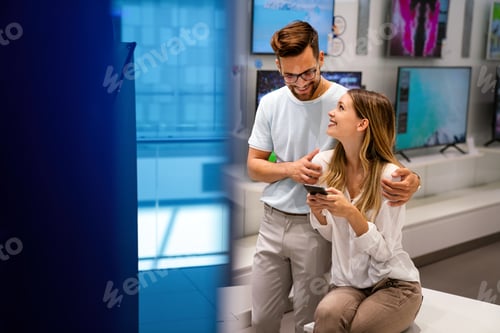 Preview: Happy people in consumer electronics retail store looking at new digital device