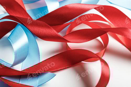 Preview: curved blue and red satin ribbons on grey background