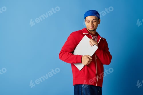 Preview: Trendy young african american man with a beanie in stylish blue background setting