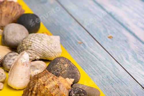 Preview: stones and shells on a blue wooden background and a yellow background.Marine theme