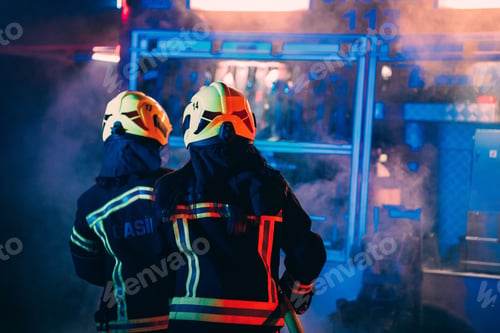 Preview: Rear view of two firefighters responding to an emergency scene with a hose
