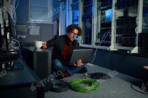 Preview: IT technician using laptop while working in data center