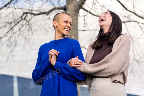 Preview: lesbian couple laughing happy in a romantic walk