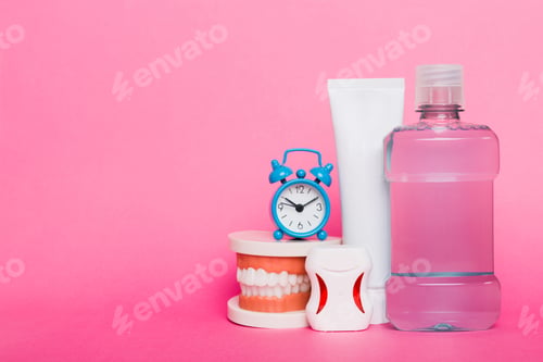 Preview: Mouthwash and other oral hygiene products on colored table top view with copy space