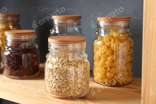 Preview: Glass jars with different products on wooden shelf, closeup
