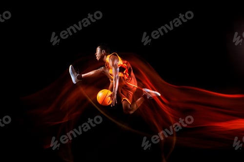 Preview: Young basketball player against dark background