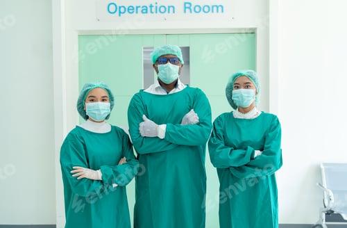 Preview: Portrait of operating doctor and nurse as team stand in front of operation room