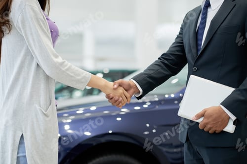 Business Handshake Agreement Inside a Modern Car Dealership