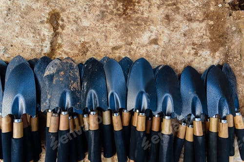 Preview: Stacked gardening shovels ready for use in a workshop.