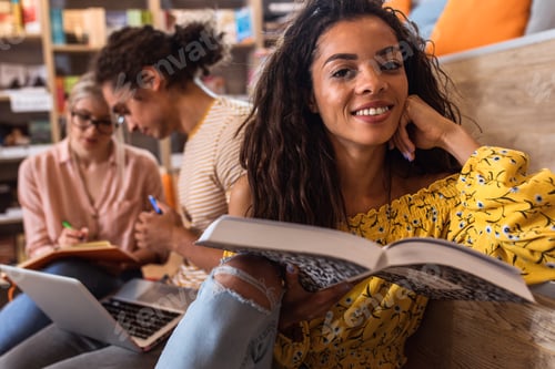 Preview: Young female student study in the library reading book.