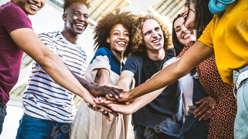 Preview: Multiracial happy young people stacking hands outside