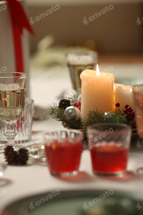 Preview: Christmas table with candles, drinks, pine branches and festive decor for holiday celebration