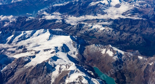 Preview: Mountains with snow from above. View out of an airplane window.