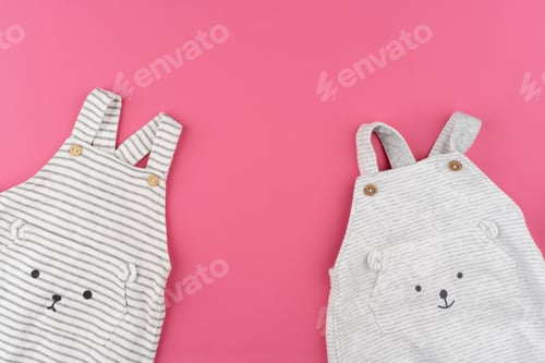 Preview: baby clothes on pink background top view