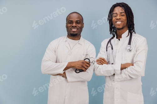 Preview: Two Young African American Doctors Smiling with Stethoscope on Blue Background