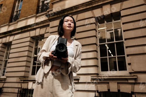 Preview: Young photographer capturing urban scenes with vintage camera in london