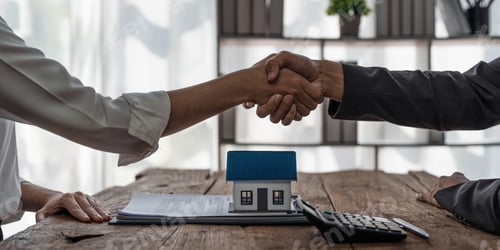 Preview: Real estate agent or realtor shakes hands with her client after making the deal in the office