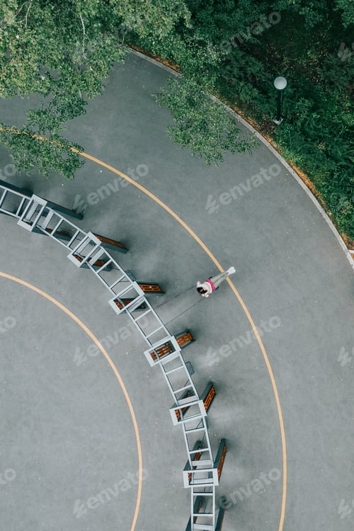 Preview: Alone woman swings on seesaw in summer park