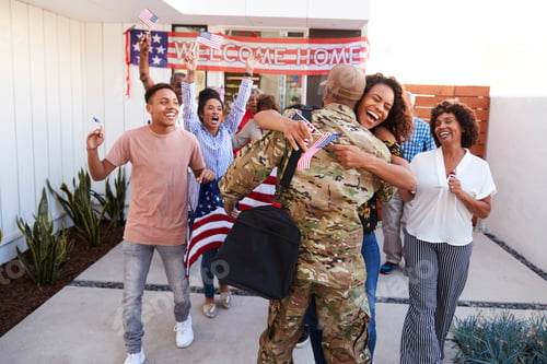 Preview: Excited three generation black family embracing millennial soldier returning home to them