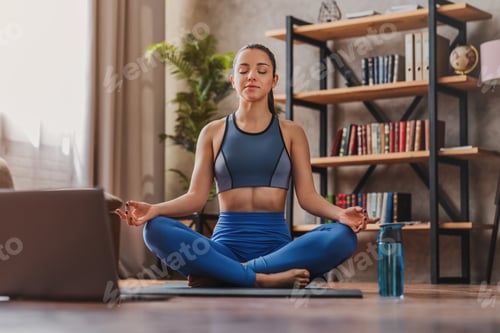 Preview: Woman Meditating at Home with Laptop Nearby