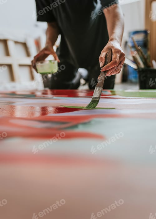 Preview: Woman artist working on her paint canvas in her studio