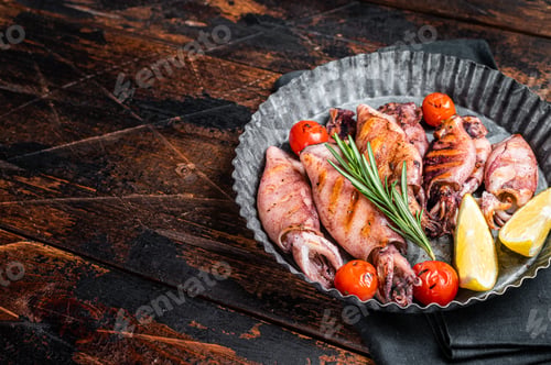 Preview: Grilled squid, calamary in a plate with herbs. Wooden background. Top view. Copy space