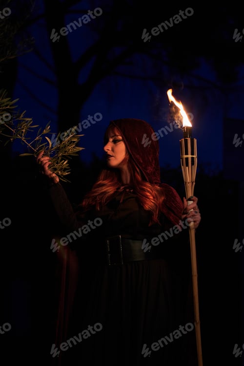 Preview: Woman disguised as a witch holding a flaming torch