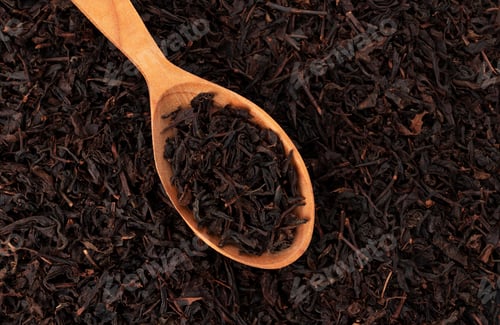 Preview: Dry tea leaves in wooden spoon isolated on dark background