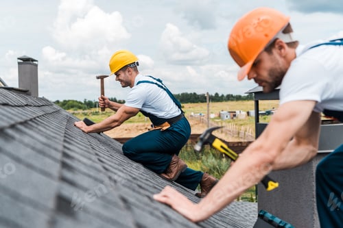 Preview: selective focus of handsome handyman repairing roof with colleague