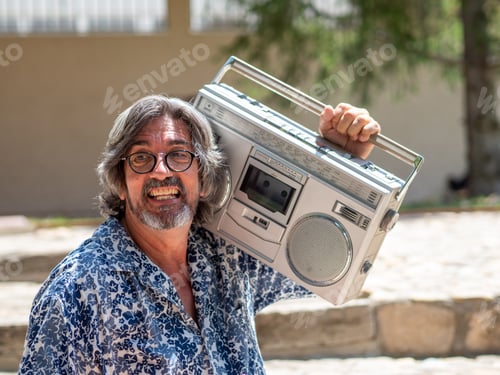 Preview: Mature man with grey hair and beard, tries to set in motion an old radio cassette