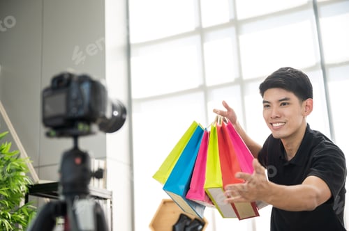 Preview: Young man recording video vlog on a digital camera and computer labtop