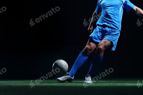 Preview: Soccer Player Doing Kick With Ball On Football Stadium Field Isolated On Black Background