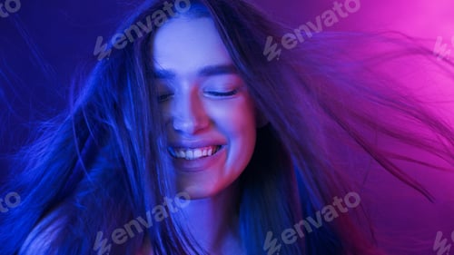 Preview: Young Woman Smiling With Blowing Hair on Neon Background