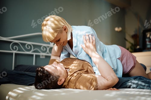 Preview: Happy female couple in love in their bedroom.
